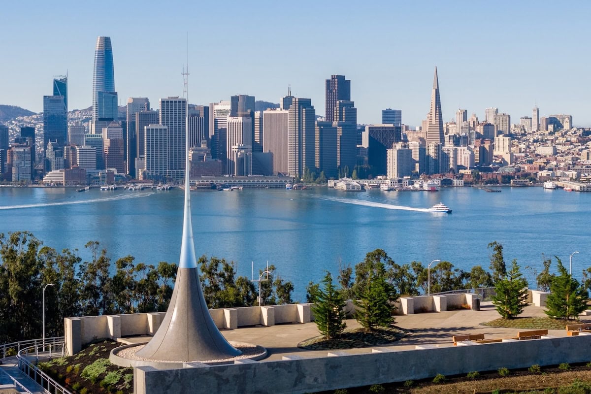 Elevated view from Treasure Island featuring a sculptural overlook, San Francisco skyline, and sparkling Bay waters on a clear day.